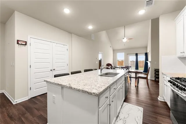 a kitchen with a stove and chairs