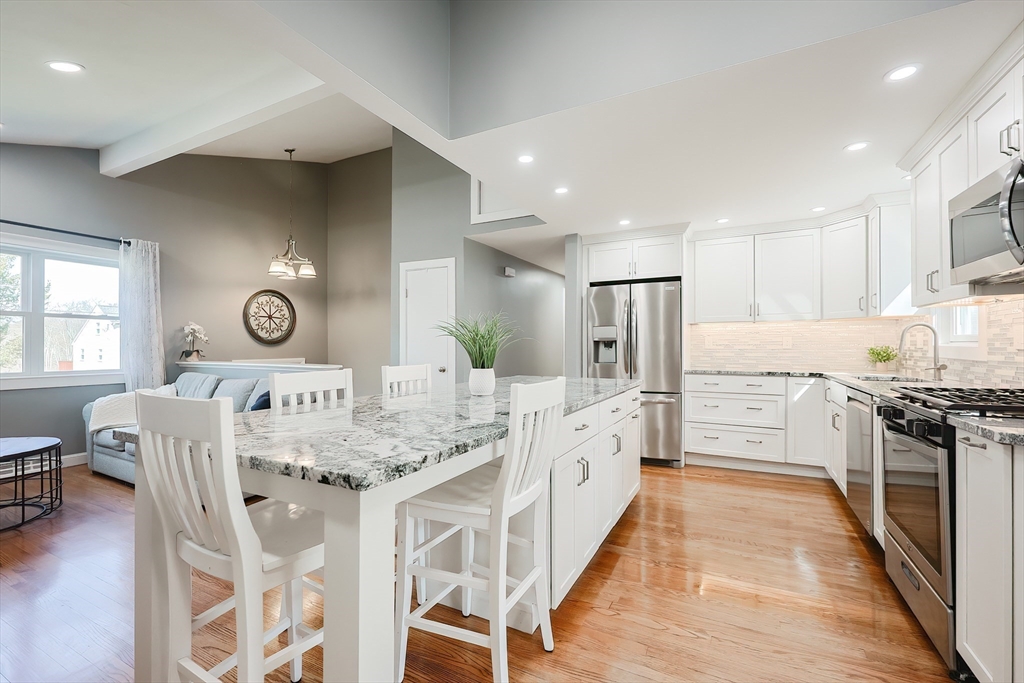 32 Anchorage Road Franklin, MA 02038 - Photo 6 of 32 a large kitchen with stainless steel appliances granite countertop a stove a sink a refrigerator and a dining table with white cabinets