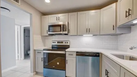 a kitchen with cabinets stainless steel appliances and sink