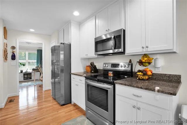 a kitchen with stainless steel appliances granite countertop a refrigerator stove and microwave