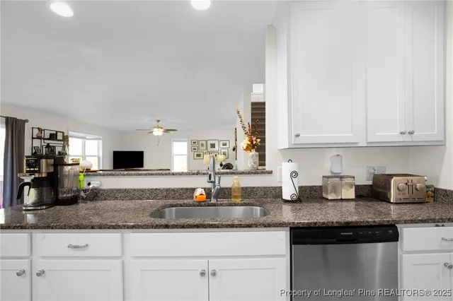 a kitchen with granite countertop a sink and cabinets