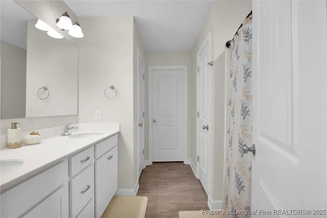 a spacious bathroom with a double vanity sink mirror and shower
