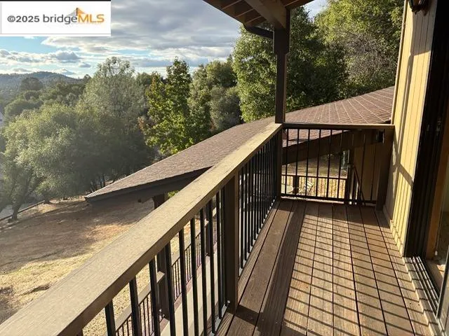 a view of a balcony with wooden floor and fence