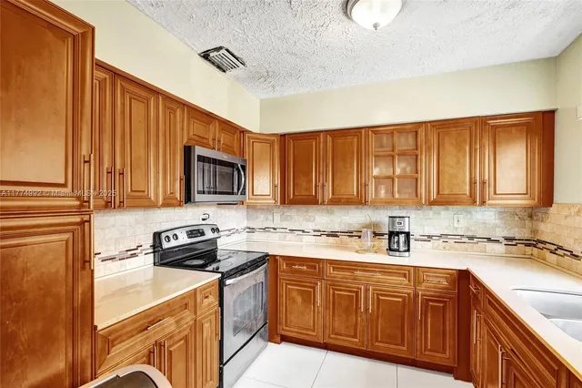 a kitchen with a sink a stove and cabinets