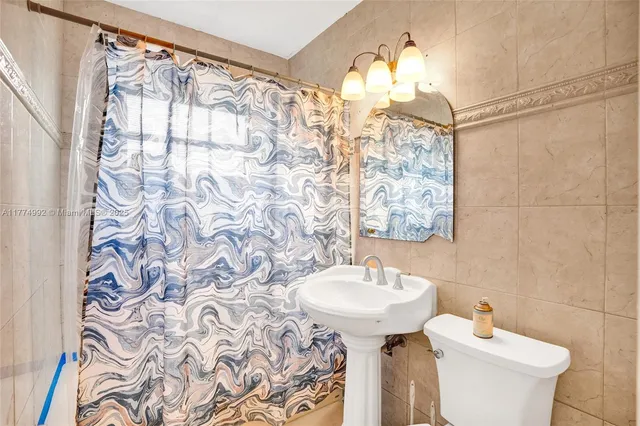 a bathroom with a sink and mirror with toilet