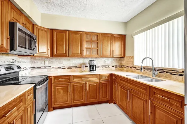 a kitchen with stainless steel appliances granite countertop a sink stove and cabinets