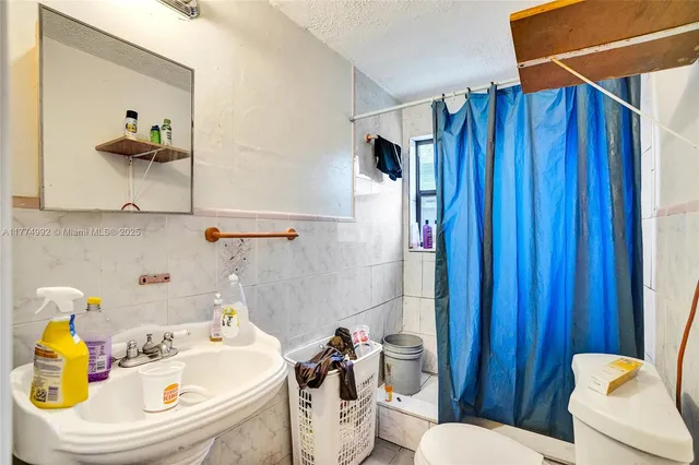a bathroom with a sink a toilet and shower curtain