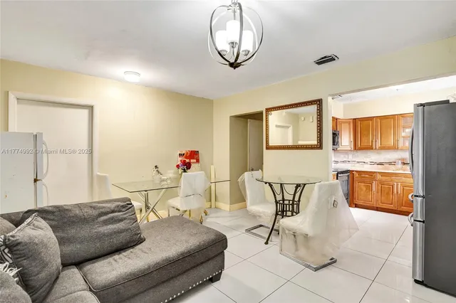 a living room with furniture a dining table and a chandelier