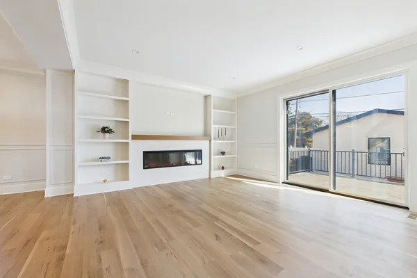 a view of an empty room with a fireplace and a window