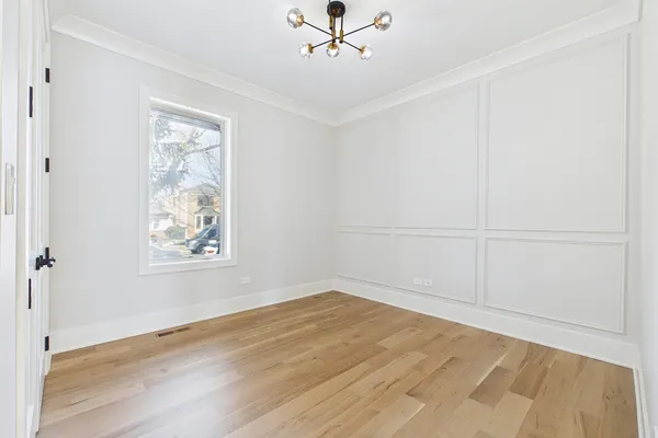 an empty room with wooden floor ceiling fan and windows