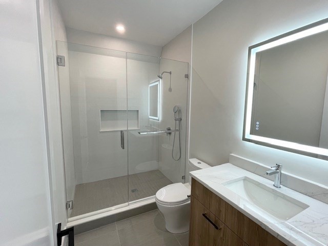246 Forest Street Needham, MA 02492 - Photo 23 of 32 a bathroom with a granite countertop sink toilet and shower