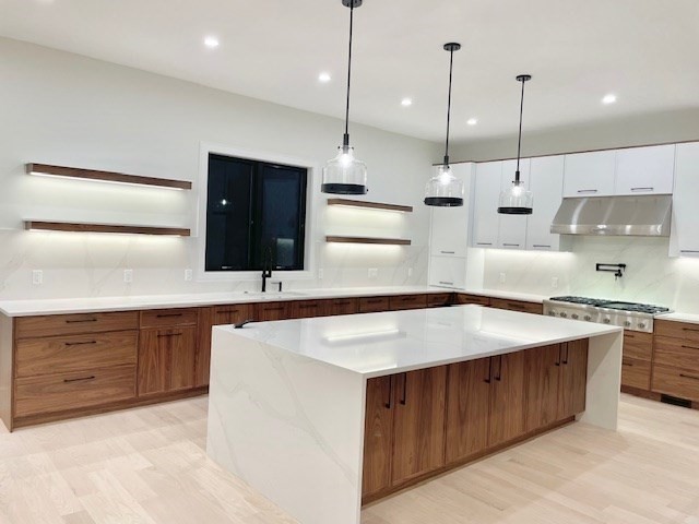 246 Forest Street Needham, MA 02492 - Photo 6 of 32 a kitchen with kitchen island a sink stove and wooden floor