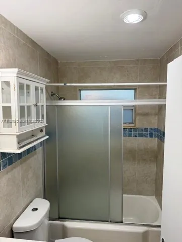 a bathroom with a shower a toilet and a sink