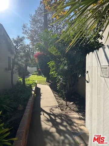 a view of a pathway of a house along trees