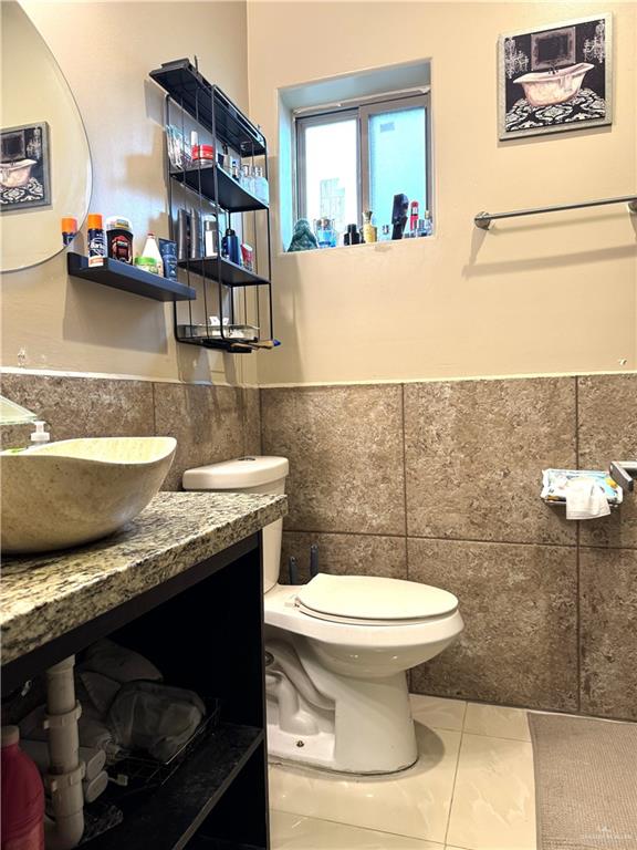 6105 South Mars Lane Pharr, TX 78577 - Photo 42 of 45 a bathroom with a toilet a sink and mirror