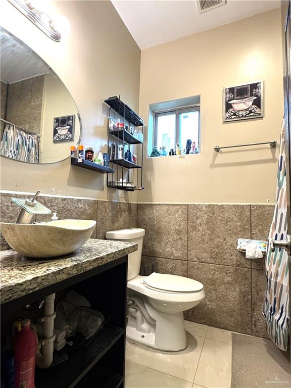 6105 South Mars Lane Pharr, TX 78577 - Photo 44 of 45 a bathroom with a granite countertop toilet sink and mirror