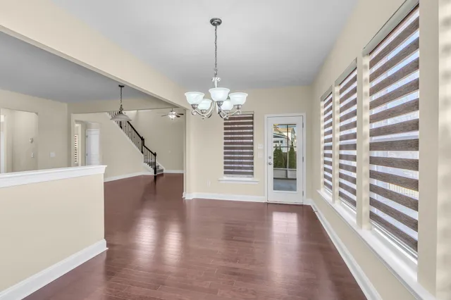 a view of a livingroom with wooden floor and a large window