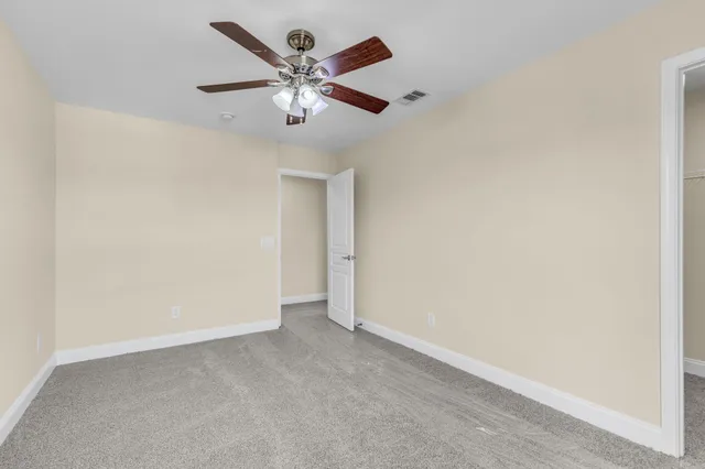 an empty room with a window and a fan