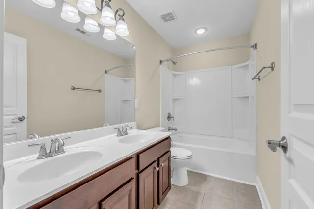 a bathroom with a granite countertop sink a toilet and shower