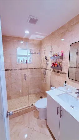 a bathroom with a sink mirror toilet and shower