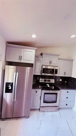 a kitchen with stainless steel appliances a stove a microwave and a refrigerator