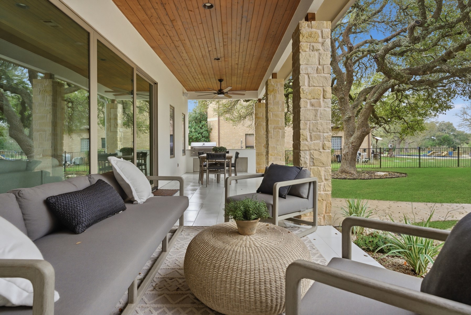 10259 Brangus Road Driftwood, TX 78619 - Photo 36 of 39 a view of a patio with couches chairs and a floor to ceiling window
