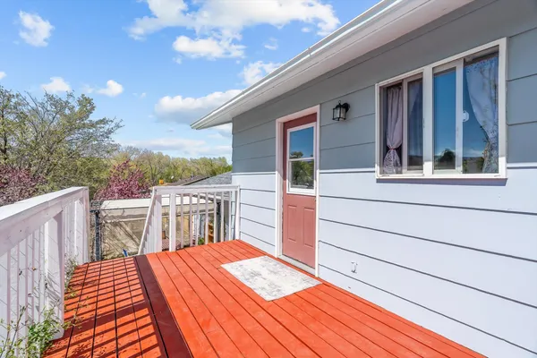 a view of a balcony with wooden floor and fence and a floor to ceiling window