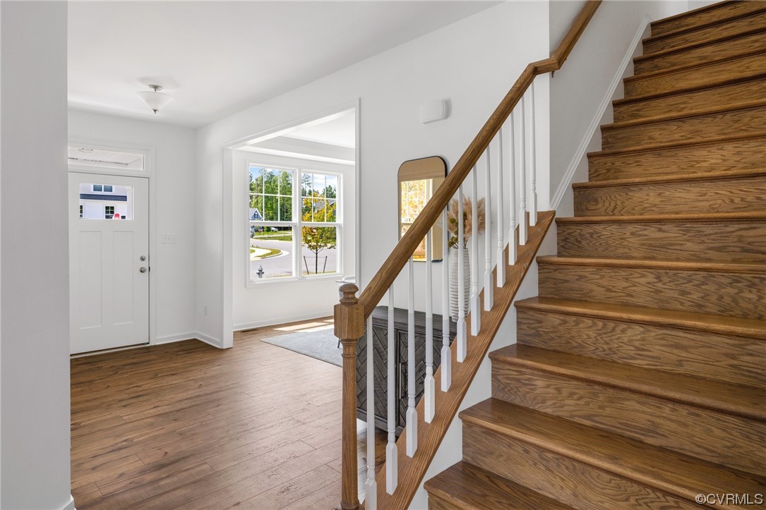 9118 Copplestone Road Chesterfield, VA 23832 - Photo 14 of 48 a view of staircase with wooden floor and a chandelier