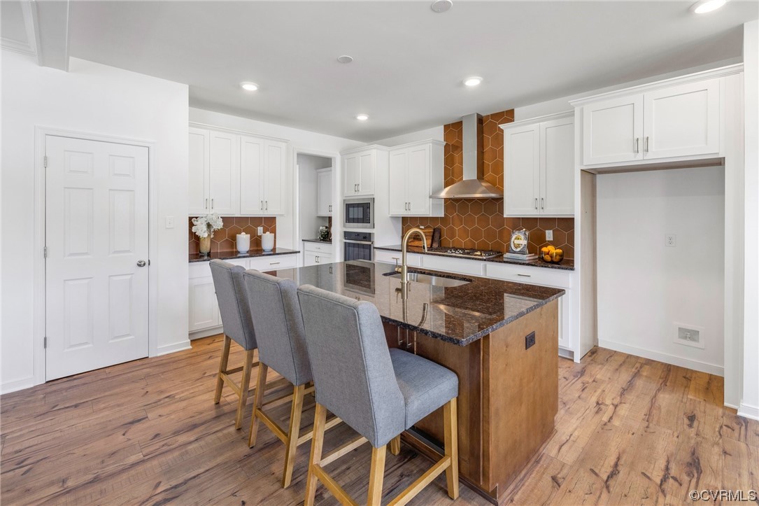 9118 Copplestone Road Chesterfield, VA 23832 - Photo 21 of 48 a kitchen with stainless steel appliances granite countertop a stove top oven a refrigerator a sink and a dining table with wooden floor