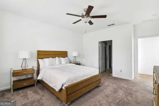 a bedroom with a bed and a ceiling fan