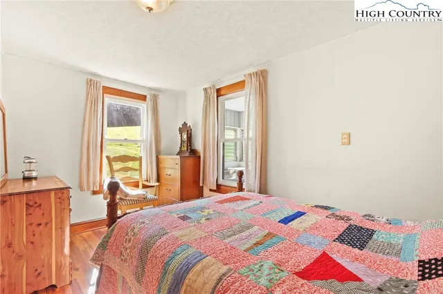 a bedroom with a bed and large windows