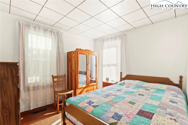 a bedroom with a bed and a dresser next to a window