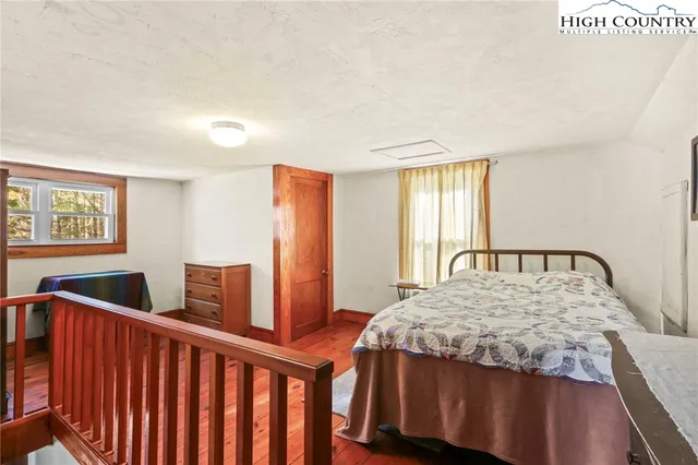 a bedroom with a bed and two windows