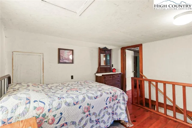 a bedroom with a large bed and a flat tv screen on dresser
