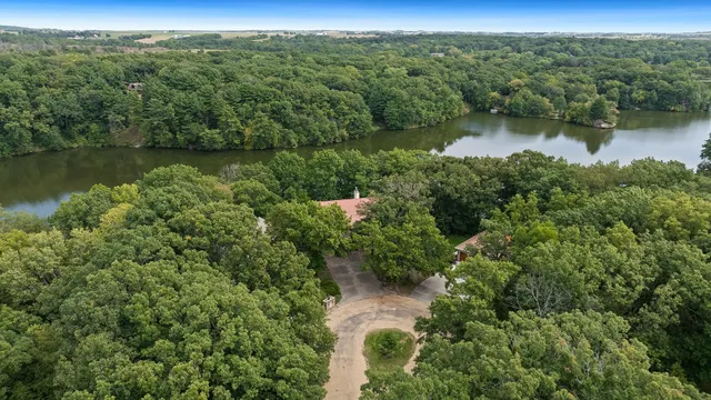 an aerial view of green landscape with trees houses and lake view