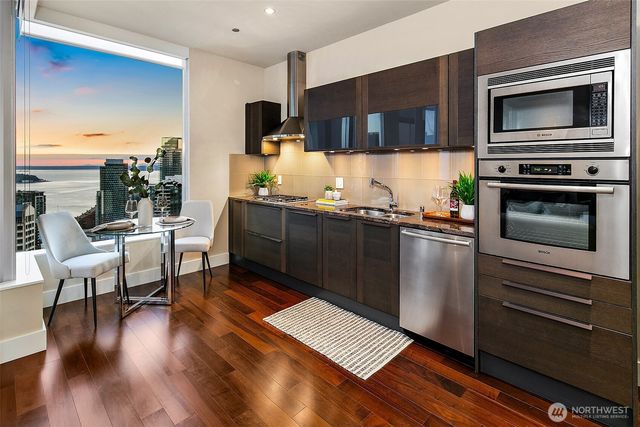 a kitchen with stainless steel appliances a stove a microwave a sink and cabinets