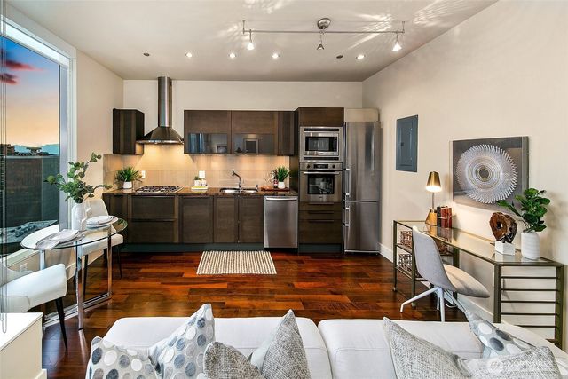 a kitchen with stainless steel appliances kitchen island granite countertop a stove and a refrigerator
