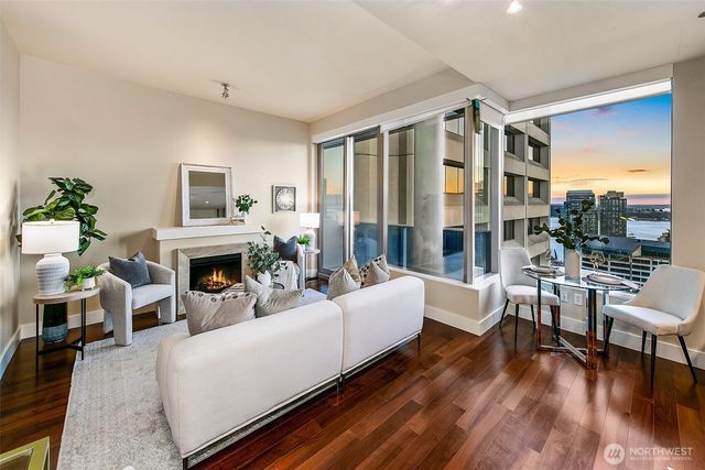 a living room with furniture a fireplace and a floor to ceiling window