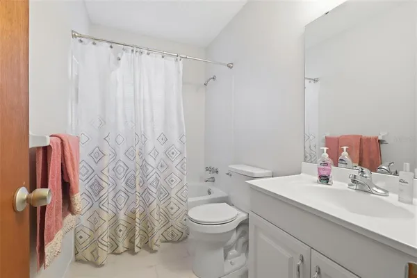 a bathroom with a sink a toilet and shower curtain