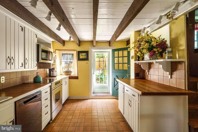 a kitchen with stainless steel appliances granite countertop lots of counter top space and wooden floor