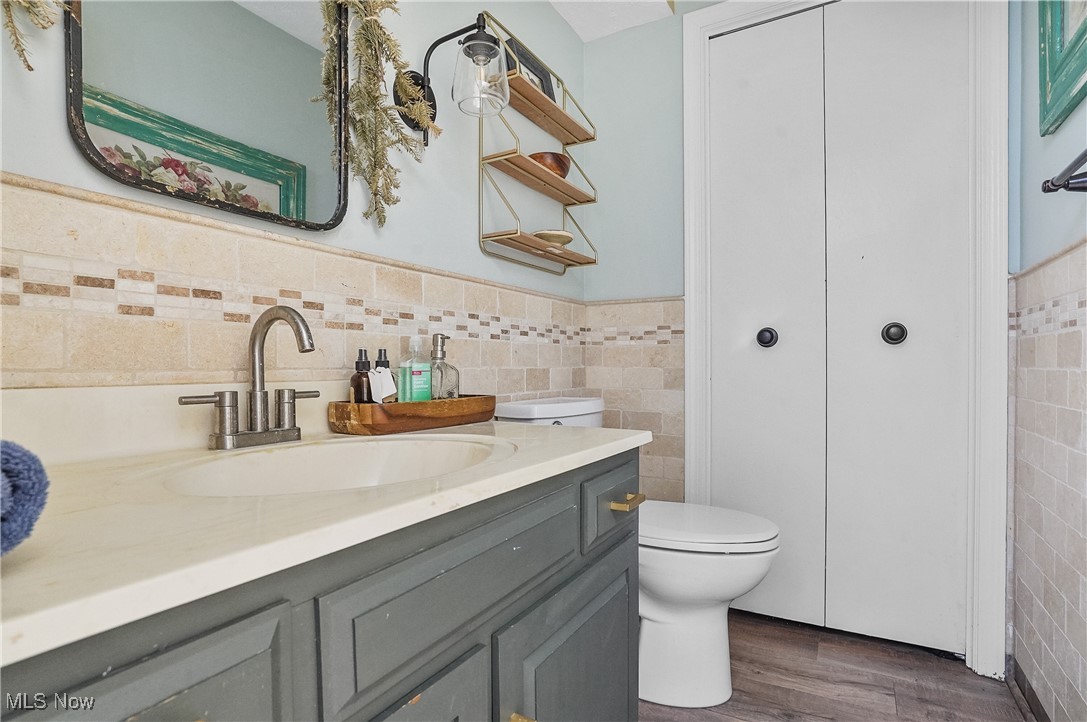 649 South Medina Line Road Akron, OH 44321 - Photo 25 of 50 Bathroom with tile walls, vanity, wainscoting, and dark wood-style floors