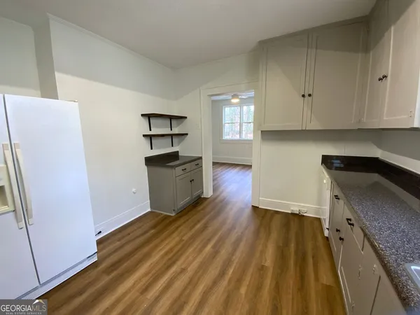 a kitchen with granite countertop a refrigerator and a sink