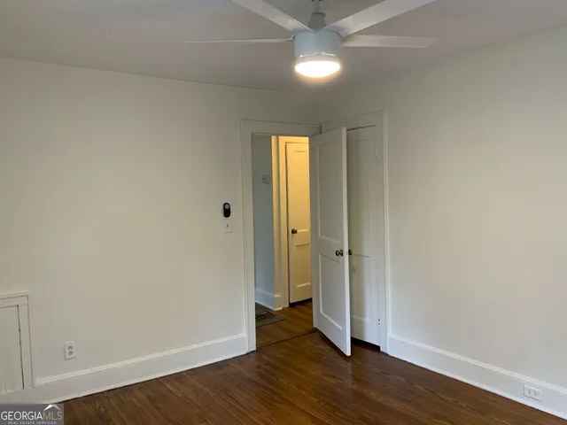 an empty room with wooden floor and closet area