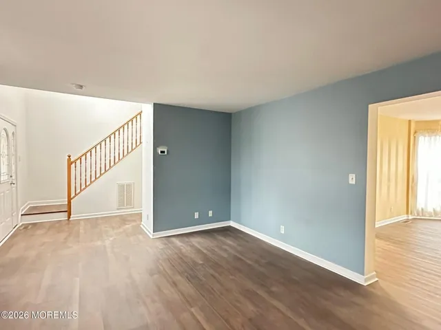 a view of a room with wooden floor and windows
