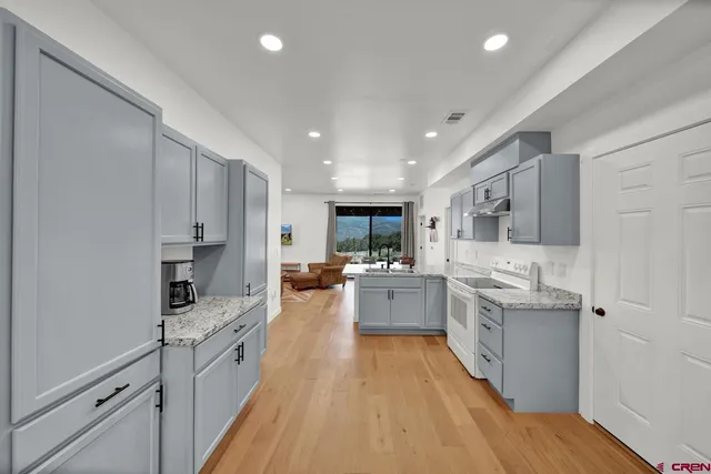 a large kitchen with stainless steel appliances lots of counter space and wooden floor