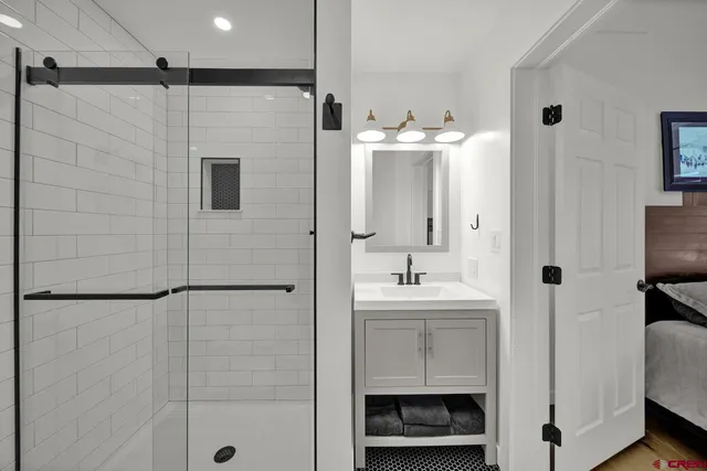 a bathroom with a double vanity sink a mirror and shower