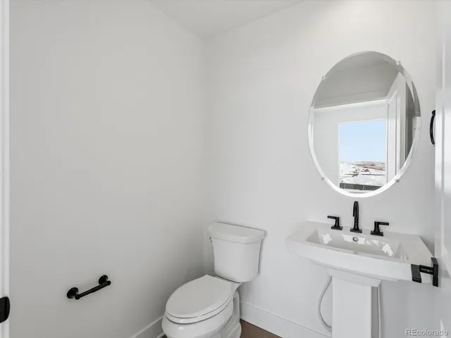 a bathroom with a toilet a sink and mirror