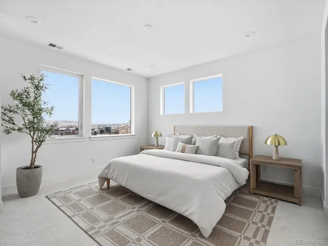 a bedroom with bed and a potted plant
