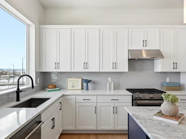 a kitchen with granite countertop white cabinets and white appliances