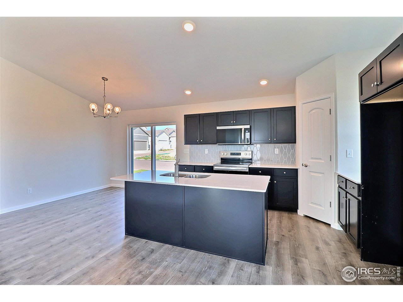 4301 Rockcress Road Evans, CO 80620 - Photo 8 of 26 a kitchen with granite countertop a stove top oven and refrigerator